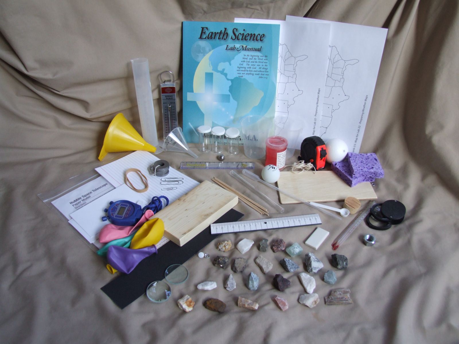 Every item in the Earth Science Kit laid out: manual, minerals, weather map sheets and instruments