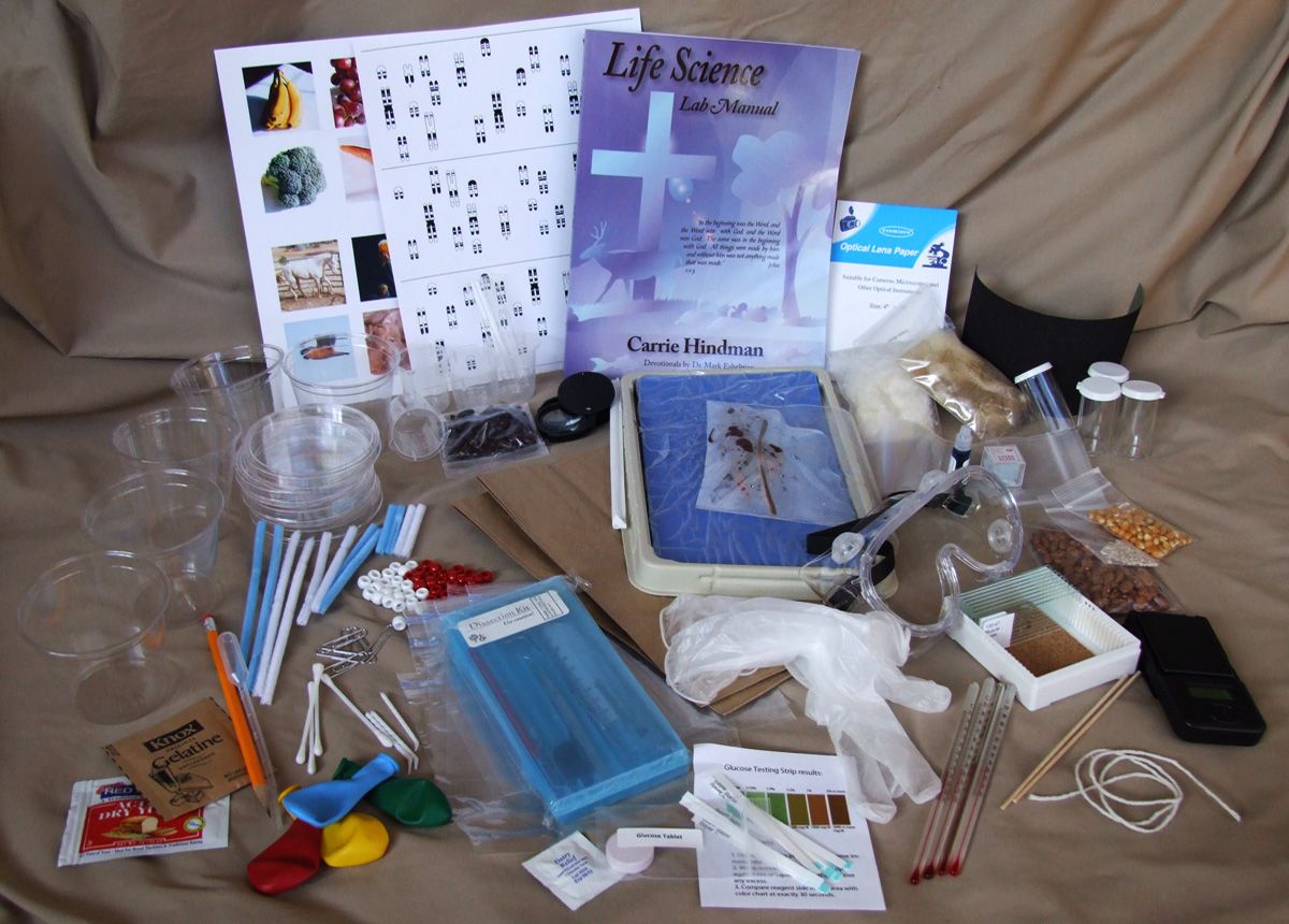 Every item in the Life Science Kit laid out: manual, dissection kit, petri dishes, karyotype sheets and glassware